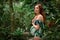 Young pregnant caucasian redhead woman in swimsuit at tropical g