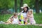 Young pregnant mother with two girls on a picnic playing