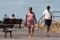 A young pregnant mother walking at the seaside with her partner