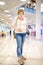 Young pregnant woman in despair because of the untied laceup in the hall of the shopping center. Problems of pregnant women with