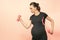 Young pregnant woman exercises with dumbell. Working out and fitness on last months of pregnancy and healthy motherhood concept.