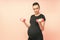 Young pregnant woman exercises with dumbell. Working out and fitness on last months of pregnancy and healthy motherhood concept.