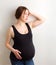 Young pregnant woman, expectant mother on white background, close-up of pregnant belly