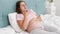 Young pregnant woman feeling sick lying in bed and coughing. Healthcare and intoxication during pregnancy