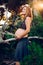 Young pregnant woman with her belly up in the air, posing carefree in the woods