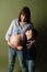 Young pregnant woman hugs her eldest son, mom and son put their hands on  big belly