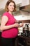 Young pregnant woman in kitchen