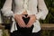 Young pregnant woman making the heart symbol with her hands on her belly in an outdoor park. Concept pregnancy, maternity, baby,