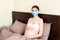 Young pregnant woman in protective medical mask is staying in bed because of. Quarantine time. Health care concept