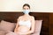 Young pregnant woman in protective medical mask is staying in bed because of. Quarantine time. Health care concept