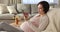 Young pregnant woman resting on cozy armchair with digital tablet