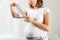 A young pregnant woman is surprised to read the instructions for using the drug. White room on the background. The concept of the