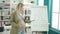 Young pregnant woman teaching maths on magnetic board touching belly at classroom