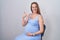 Young pregnant woman wearing band aid for vaccine injection smiling happy and positive, thumb up doing excellent and approval sign