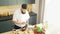 Young prepares a poke bowl in a modern kitchen. The man prepares food at home. Cooking healthy food.