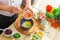 Young prepares a poke bowl in a modern kitchen. The man prepares food at home. Cooking healthy and tasty food.