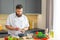 Young prepares a poke bowl in a modern kitchen. The man prepares food at home. Cooking healthy and tasty food