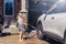 Young preschool girl washing car on driveway in front house on summer day. Kids home errands duty chores responsibilities concept