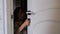 Young preschooler boy with long hair opens white door