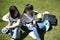 Young and pretty asian tourist couple checking social media on their cell phones sitting on the grass in the city during their