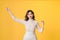 Young pretty Asian woman smiling with energetic movement studio shot isolatede on colorful yellow background
