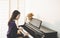 Young pretty beautiful Asian girl sitting at piano