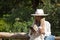 Young, pretty, blonde-haired woman with green eyes, wearing a white shirt and hat, holding a coffee in her hand and checking