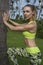 Young pretty blonde happy female wearing exercise clothing stretching leaning against palm tree during beautiful summer day.