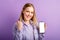 Young pretty blonde woman show empty smartphone screen mockup. Happy smiling woman celebrating success with phone empty