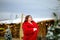 Young pretty brunette woman in red long coat skating at the open skating rink. Christmas background