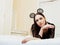Young pretty brunette woman wearing lace mouse ears, laying waiting dreaming in bed
