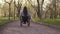 Young Pretty disabled woman in wheelchair walking in the park at evening time