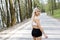 A young, pretty girl blonde runs outdoors in the woods near the lake with beautiful scenery. Sports activity. Exercise