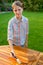 Young pretty girl holding a brush applying varnish paint on a wooden garden table