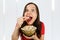 Young pretty girl with opened mouth and wide eyes holds glass bowl with popcorn