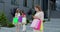 A Young Pretty Girl Standing In A Front Of A Shopping Mall With Phone And Shopping Bags In Her Hands. A Group Of Women