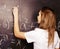 Young pretty girl student in classroom at blackboard