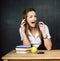 Young pretty girl student in classroom at blackboard doing homework