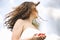 A Young Pretty Girl In The White Dress Standing Against Sky With Red Rose In The Hands.