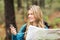 Young pretty hiker using compass and map