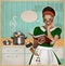 Young pretty housewife cooks in the kitchen.Retro card on old pa