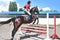 Young pretty jockey girl preparing horse for ride. love horses. girl riding a horse