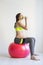 Young pretty pregnant woman sitting on fitness ball