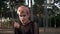 Young Pretty Punk Girl in Collar and Net. Pink Hair Girl walking in Pine Forest at Sunset Time