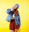 Young pretty red hair teenage hipster girl posing in glasses emotional happy smiling on yellow background, lifestyle