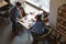 Young pretty smiled woman sitting at table with coffee in cafe and man coming for meeting.