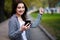 Young pretty stylish exulting woman holding smart phone in the s