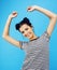 Young pretty teenage modern hipster girl posing emotional happy smiling on blue background, lifestyle people concept