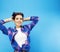 Young pretty teenage modern hipster girl posing emotional happy smiling on blue background, lifestyle people concept