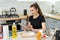 Young pretty wife preparing cookies at home with help digital tablet